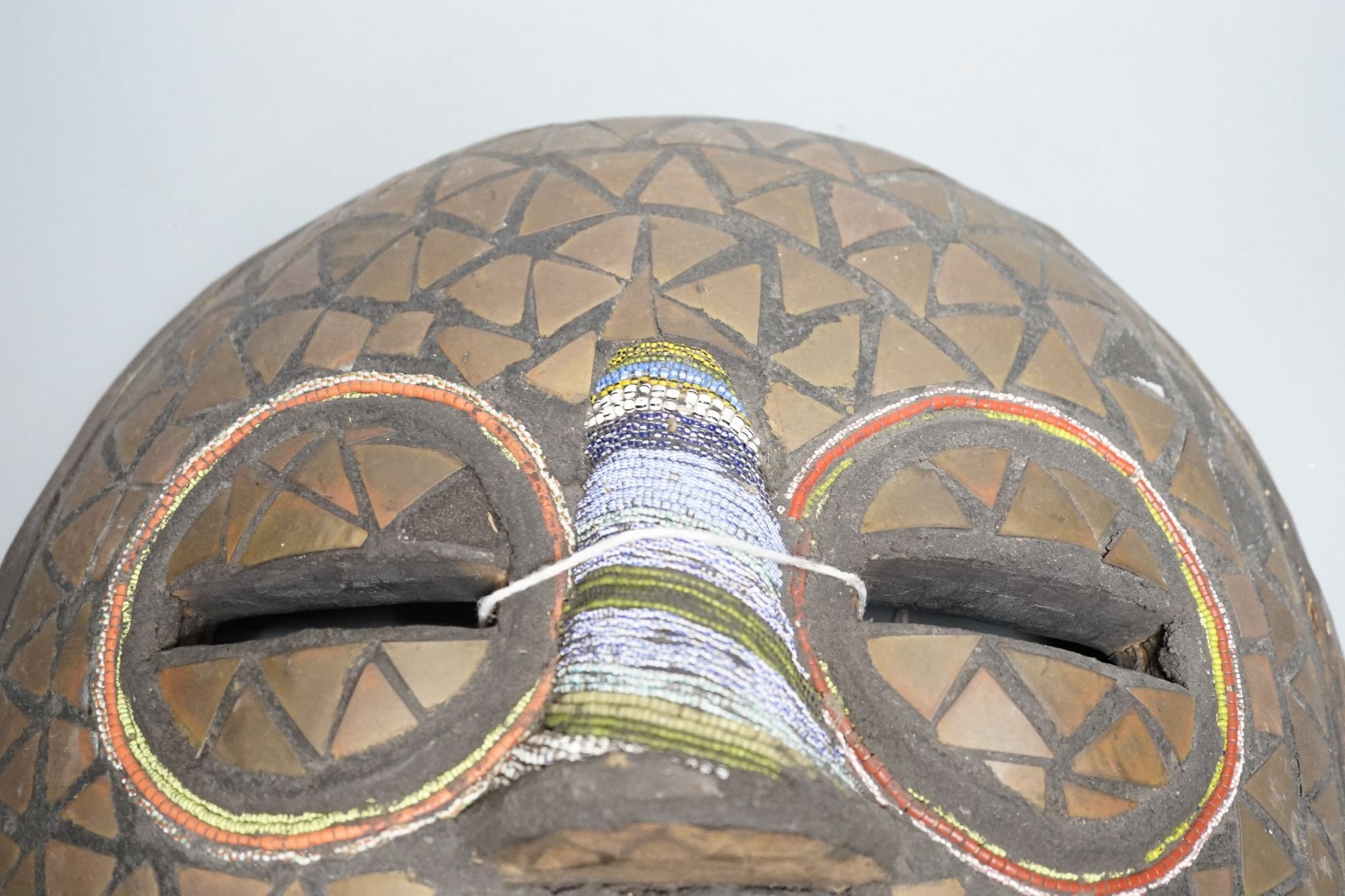 Two Japanese carved wood masks, an African beaded mask and three similar rattles